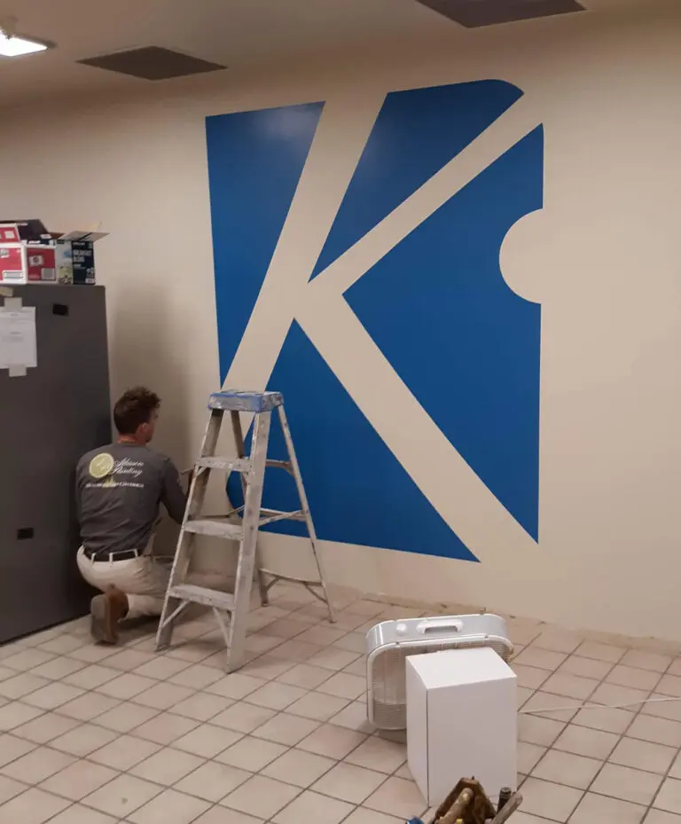 Atkisson Painting - Painting a logo on a wall of a local business